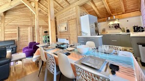 A wooden interior with a dining area, kitchen, and seating. - Luxury Chalet with Spa & Sauna in Vars (Vars)