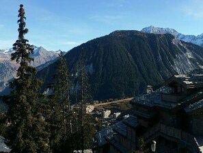 A traditional wooden building with a mountain backdrop.