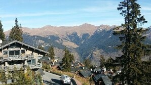 Eine Berglodge mit einer Zufahrtsstraße, umgeben von Bäumen und Bergen.