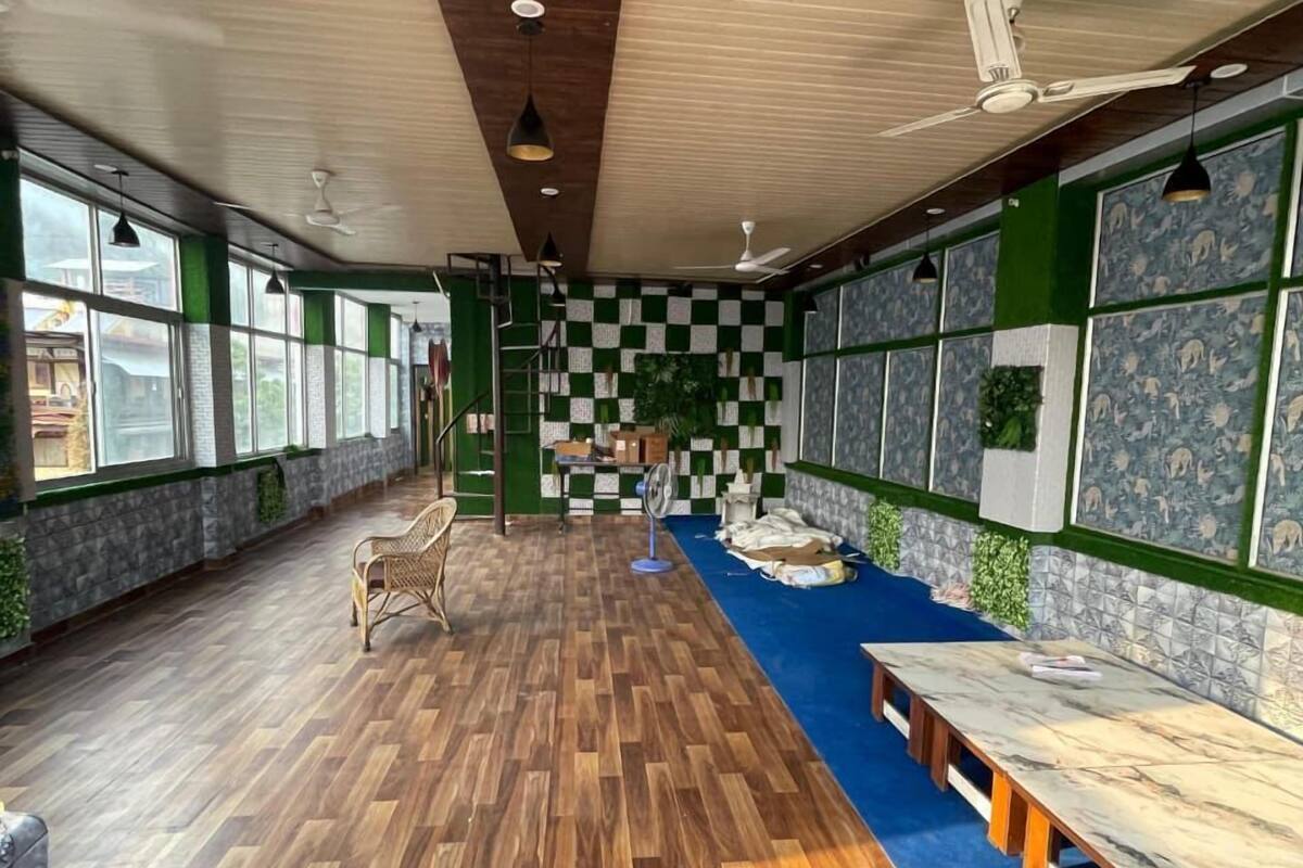 A spacious room with a wooden floor, a long table, and a blue carpeted area.