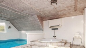 A modern bathroom with a freestanding bathtub, a shower, and a white tiled floor.