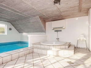 A modern bathroom with a freestanding bathtub, a shower, and a white tiled floor.