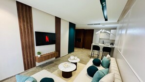 A modern living room with a sofa set, a coffee table, and a flat-screen TV mounted on the wall. - StayInn - Pavillon Les Princesses (Casablanca)