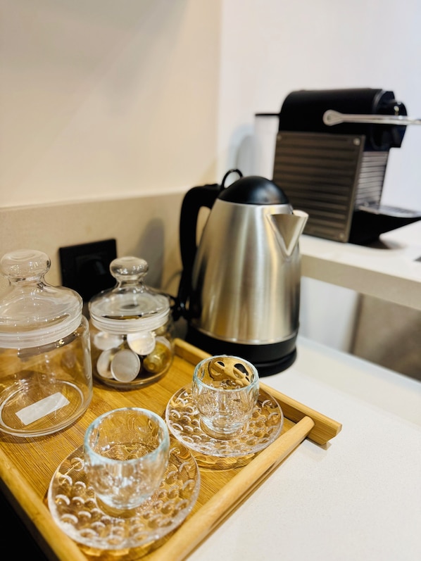 Una bandeja con recipientes de vidrio y una cafetera sobre una encimera.