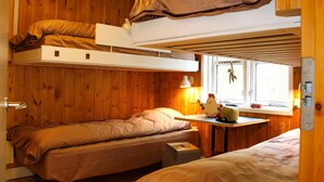 A cozy room with two bunk beds, a small table with toys, and a window with a view. - 6 Person Holiday Home in Vaeggerlose (Vaeggerlose)