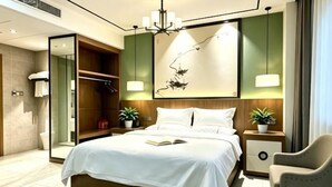 Una habitación de hotel moderna con una cama grande, mesitas de noche, una silla, un armario y un espejo.