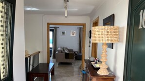 A hallway with a wooden bench, a dining table, a sofa, and a cabinet with a lamp. - Altea Hills Hideaway With Stunning Views (Altea)