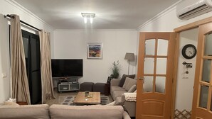 A living room with a sofa, a coffee table, a TV, and a door. - Altea Hills Hideaway With Stunning Views (Altea)