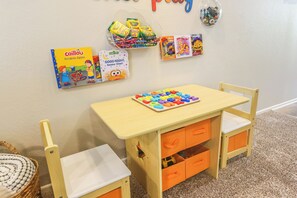 A child's play area with a table, chairs, and educational toys. - NCV C4 Beautiful beachfront cottage, all new furnishings w/ Stunning Ocean views (Oceanside)