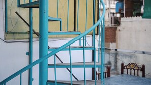 A spiral staircase with teal railings leading to an upper floor. - Hostel Funky Bunky  (Udaipur)