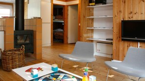 A cozy living room with a fireplace, wooden shelves, a flat-screen TV, and comfortable seating. - 6 Person Holiday Home in Vaeggerlose (Vaeggerlose)