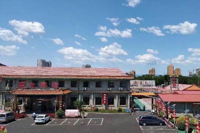 A traditional building with a tiled roof, a parking lot, and a clear sky.