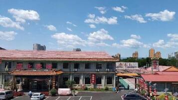 A traditional building with a tiled roof, a parking lot, and a clear sky.