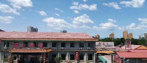 Un edificio tradicional con techo de tejas, estacionamiento y cielo despejado.