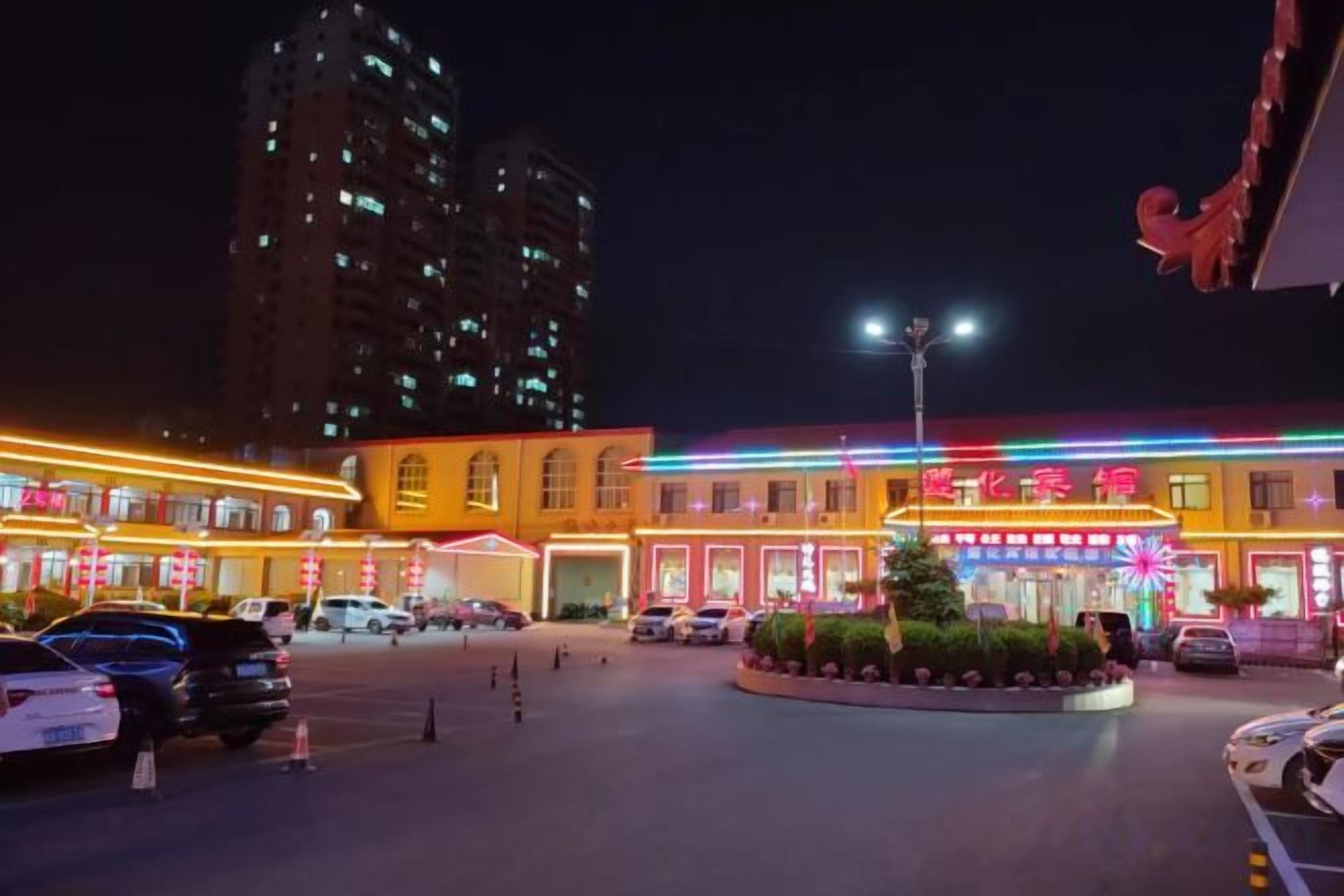 Un hotel con patio central, varios pisos y señalización iluminada.