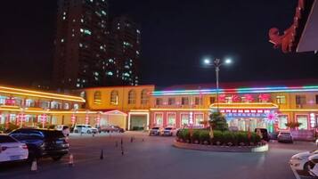 Un hotel con patio central, varios pisos y señalización iluminada.