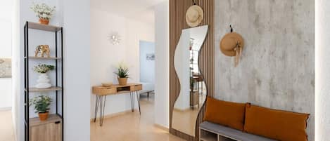 Una sala de estar moderna con un sofá, una mesa de centro y un espejo decorativo.
