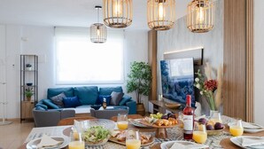 Un espace repas moderne, aménagé pour le petit-déjeuner, avec des assiettes, des verres et une variété d’aliments.