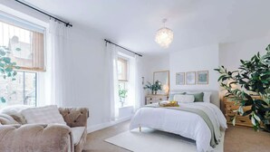 A bedroom with a bed, a sofa, a chandelier, and a large plant. - Rufloreo Dale (Derbyshire)