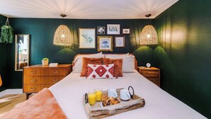 A bedroom with a bed, bedside tables, a dresser, and a breakfast tray with food and drinks. - Rufloreo Flats 1a  cosy and central (Derbyshire)