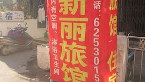 A red banner with yellow text advertising a new hotel, including a phone number. - Yueqing Xinli Hotel (Yueqing)