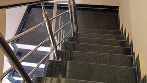 A staircase with metal railings and black steps. - Ajay Palace Home Stay (Faizabad)