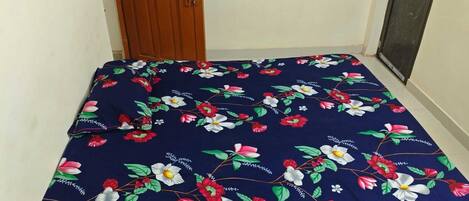 A small room with a bed covered in a floral bedspread.