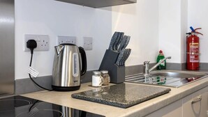 Eine Küche mit Wasserkocher, einem Messerblock und einem Feuerlöscher.