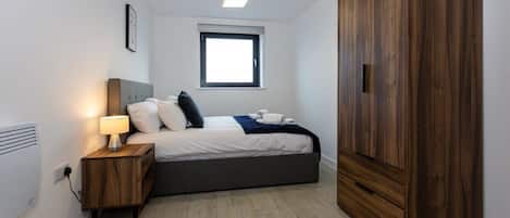 2 habitaciones, escritorio y tabla de planchar con plancha