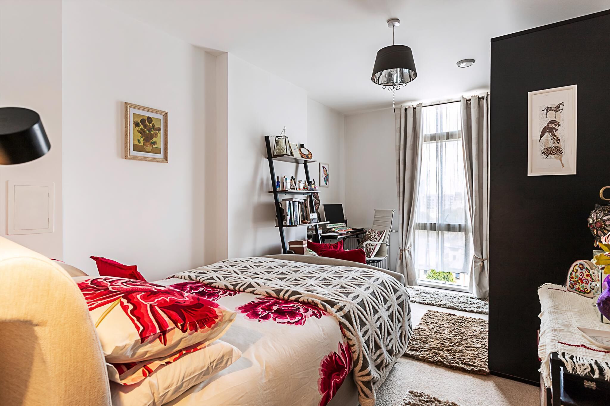 A bedroom with a bed, a desk, a chair, a bookshelf, and a window with curtains.