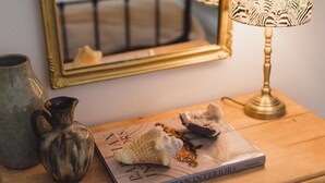 A book titled 'Parisian Interiors' on a wooden table, accompanied by a lamp and a vase. - Seaside Escape Cottage in Broadstairs (Broadstairs)