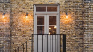 A brick building with a white-framed window and a black metal gate. - Seaside Escape Cottage in Broadstairs (Broadstairs)