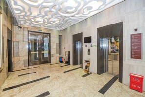 An interior with two elevators, marble flooring, and a decorative ceiling. - Jinjiang Tianhe Grand Hotel (Jinjing People's Government) (Jinjiang)