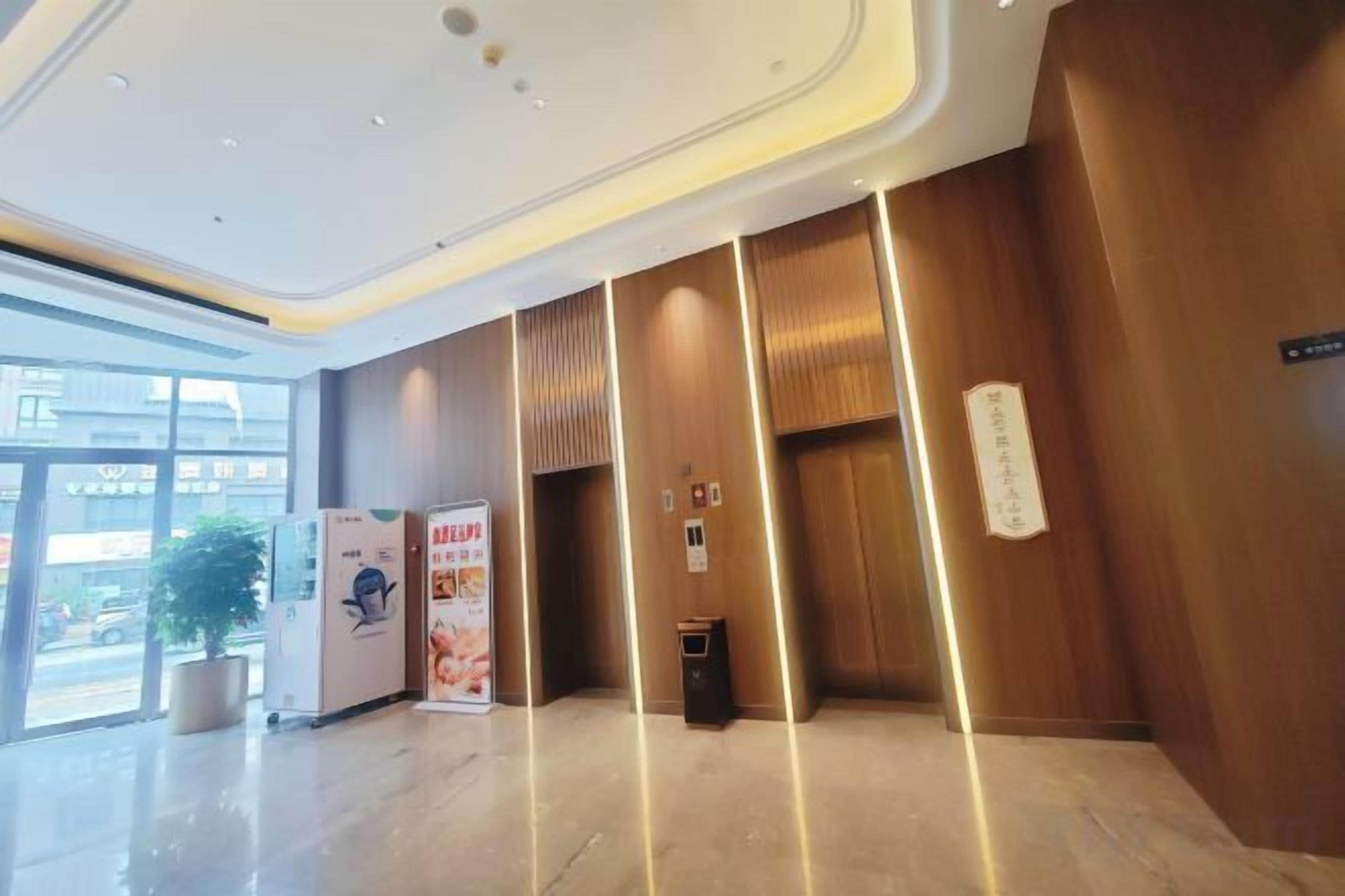 A modern lobby with a reception desk, a vending machine, and a trash bin.