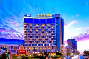 A multi-story hotel with a modern design, featuring a prominent signage at the top. - Jinjiang Tianhe Grand Hotel (Jinjing People's Government) (Jinjiang)