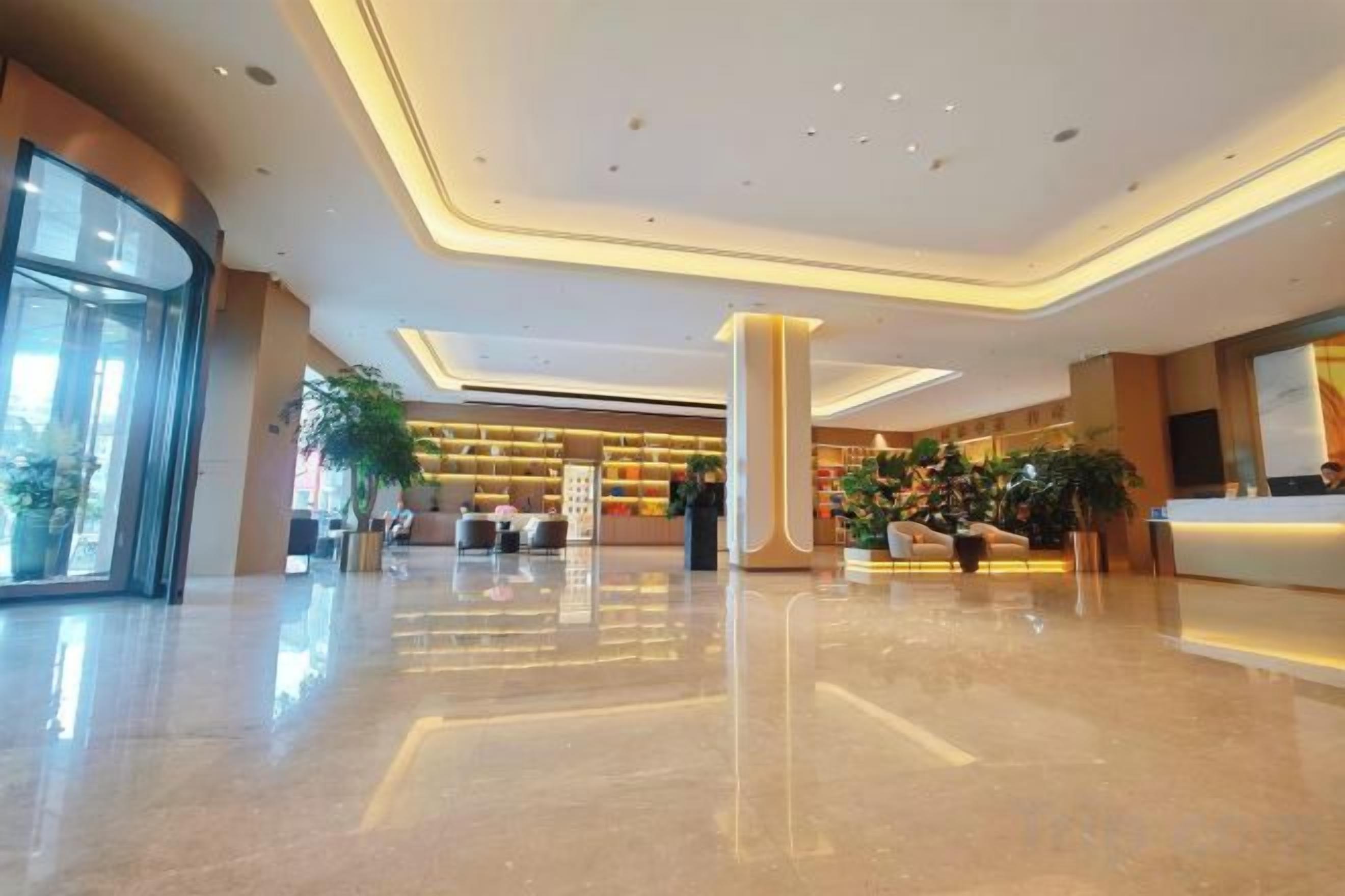 A spacious lobby with a reception desk, seating area, and large windows.