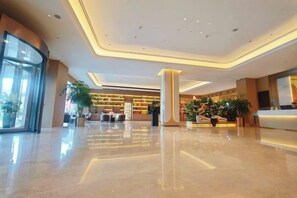 A spacious lobby with a reception desk, seating area, and large windows. - Jinjiang Tianhe Grand Hotel (Jinjing People's Government) (Jinjiang)