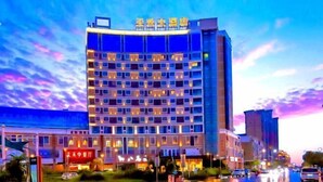 A multi-story hotel with a modern design, featuring a prominent sign at the top and multiple balconies. - Jinjiang Tianhe Grand Hotel (Jinjing People's Government) (Jinjiang)