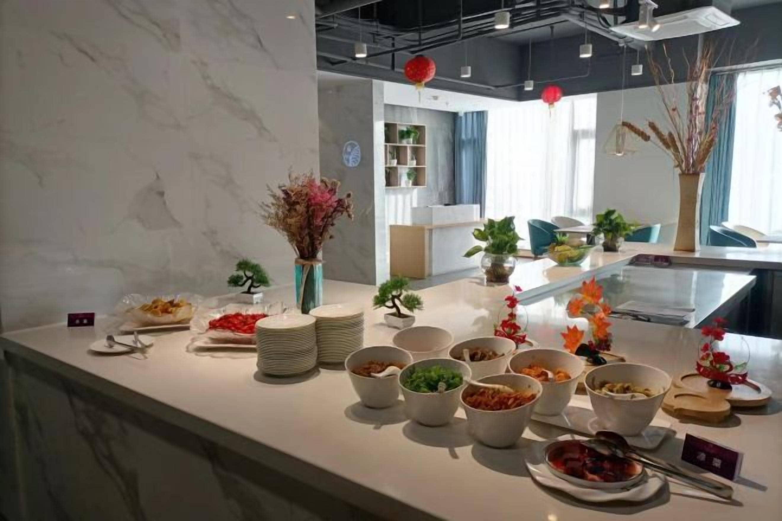 Ein reichhaltiges Buffet mit verschiedenen Speisen und einer Vase getrockneter Blumen.