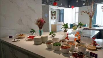 Ein reichhaltiges Buffet mit verschiedenen Speisen und einer Vase getrockneter Blumen.
