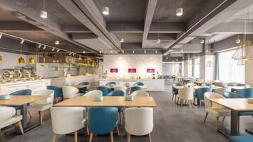 Un espace repas moderne avec des tables et des chaises, un bar et un comptoir avec un présentoir.