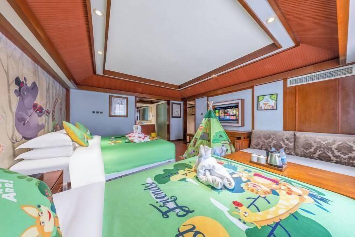 A children's room with bunk beds, a play area, and a television.