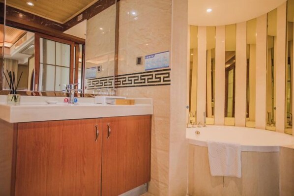 A bathroom with a wooden vanity, a white countertop, and a large mirror. - Bingang International Hotel (Xishuangbanna Splash Plaza) (Jinghong)