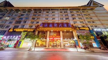 A hotel with multiple floors, a prominent entrance, and various signage.