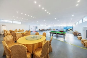A spacious indoor area with round tables and chairs, a pool table, and a billiards table. - Bingang International Hotel (Xishuangbanna Splash Plaza) (Jinghong)