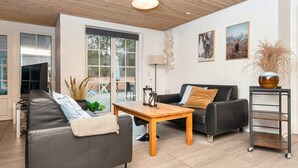 A modern living room with a sofa, a coffee table, and a TV. - 4 Star Holiday Home in Ulfborg (Ulfborg)
