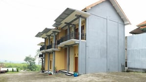 Un edificio residencial moderno de dos pisos con un balcón en el nivel superior.