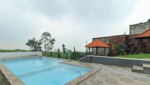 Una piscina rectangular con una solana con mosaicos alrededor.