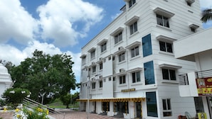 Un hôtel à plusieurs étages, doté d’une façade blanche, de balcons et d’une enseigne indiquant « SAAI RETREAT HOME ».
