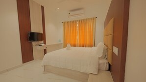Une chambre d’hôtel équipée d’un lit, d’une télévision, d’un bureau et d’un appareil de climatisation.